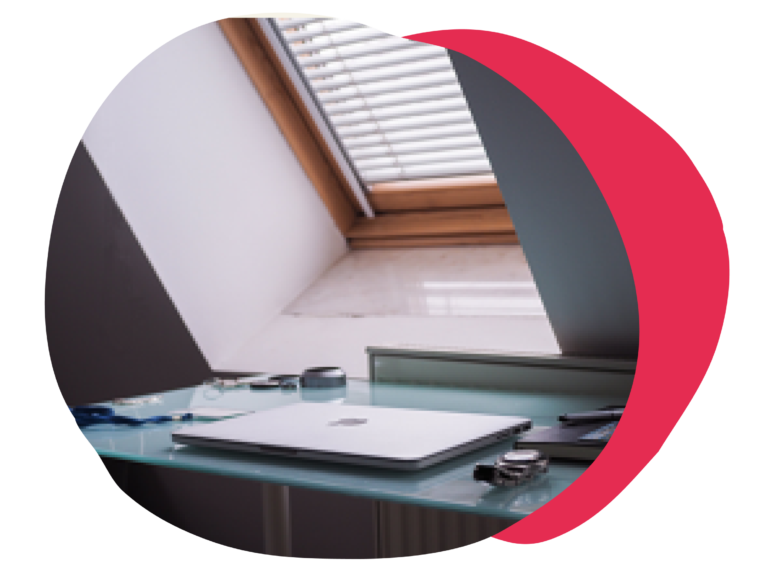 desk with laptop under skylight, modern workspace setup, organized with stationery and blue accents, natural light through window