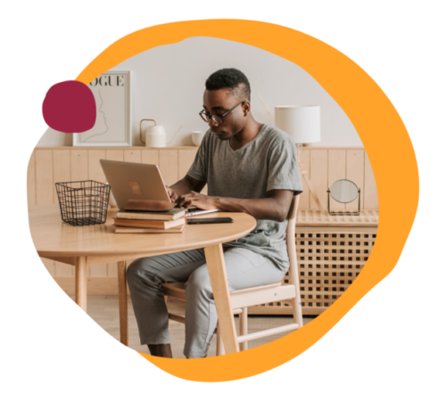 man working on a laptop at a modern wooden table in a cozy room, home office workspace with stylish decor and accessories