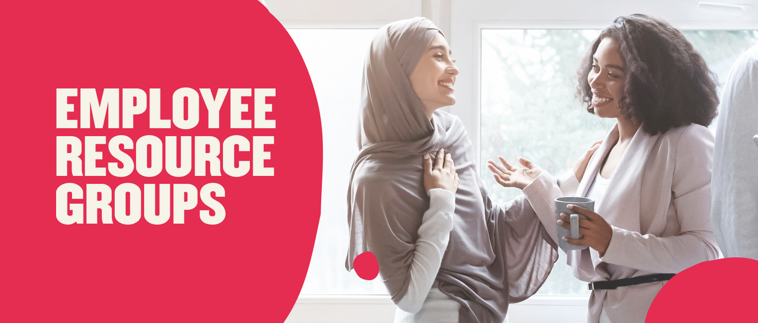 EMPLOYEE RESOURCE GROUPS fostering community; women engaged in conversation, one holding a coffee mug, bright window backdrop, diversity, collaboration