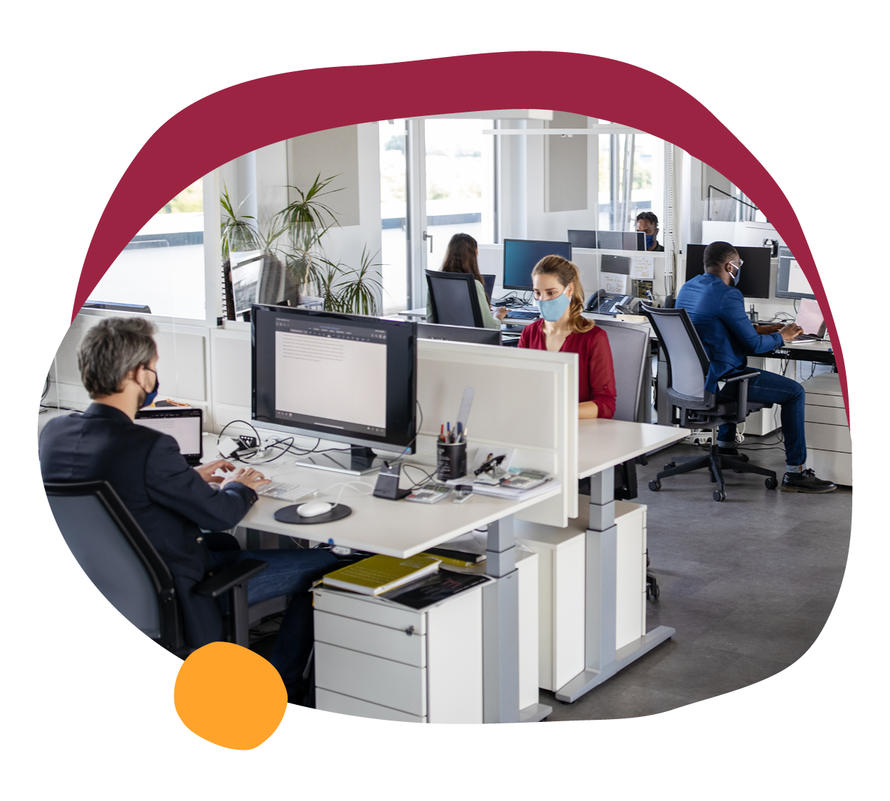 office workspace with employees in masks, modern desk arrangements and technology in a bright environment