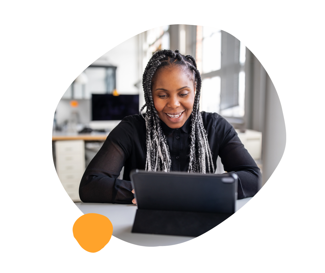 professional woman with braided hair using a tablet in a bright office space, modern workspace with technology and focus
