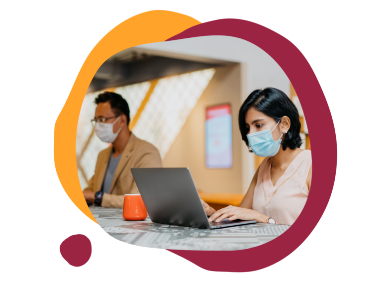 working professionals in masks using laptops in a modern workspace with orange and maroon abstract shapes, office environment with a casual feel and focus on productivity