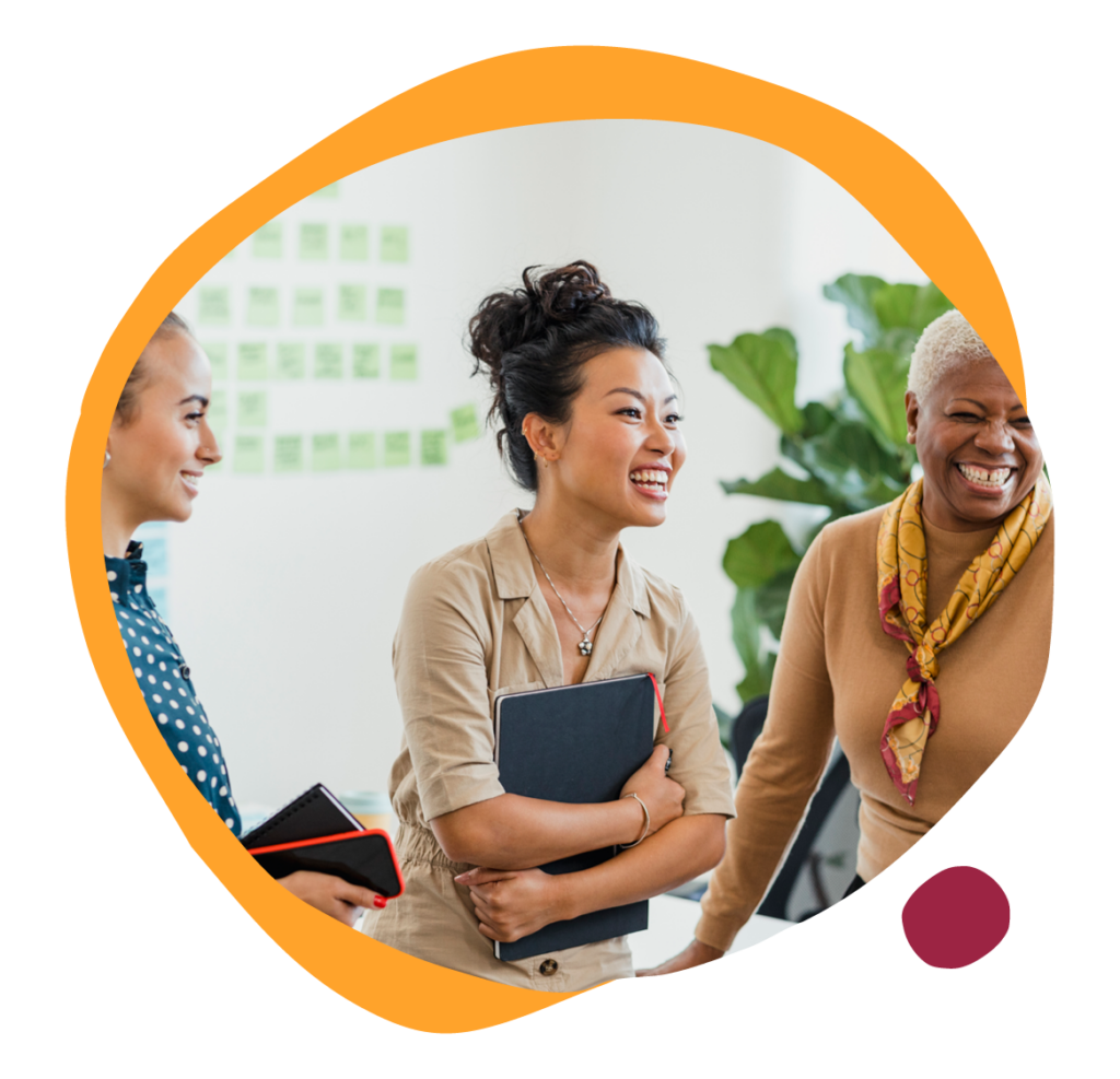 women laughing, diverse team in modern workspace