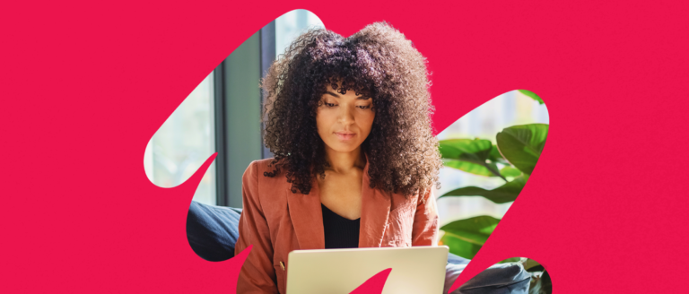woman with curly hair working on a laptop, vibrant pink background, indoor setting with plants, professional woman focused on laptop