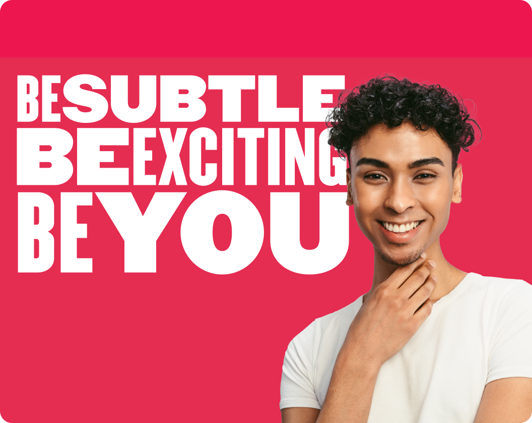 Be Subtle, Be Exciting, Be You slogan with a smiling young man in a casual white shirt against a bright pink background. , youthful_promotion, positive_message