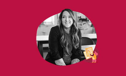 professional woman sitting in a creative workspace smiling, black and white image with pink background, showcasing a joyful atmosphere